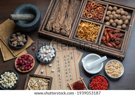 Ancient Chinese medicine books and herbs on the table.English Translation:Traditional Chinese medicine is used in the prevention and treatment of diseases, has the function of rehabilitation. Imagine de stoc © 