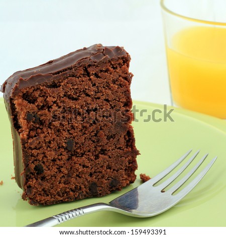 chocolate cake on the green plate with a glass of juice