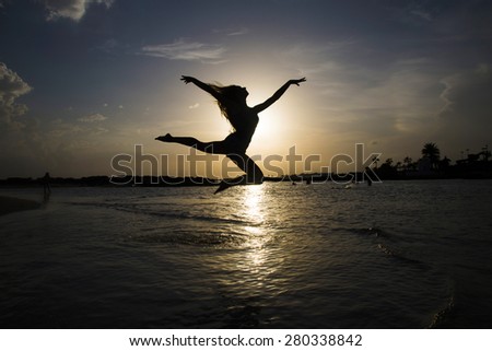 girl jumping on a background of sunset and sea