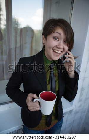 Asian girl with a cup of tea on a background of a window