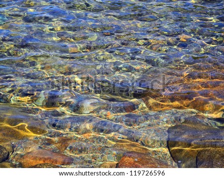Impressionistic image of sunlight playing over the water\'s surface on Jordan Pond in Acadia, creating webs and spangles of light in an abstracted realism composition.