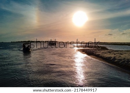 Some silhouettes of boats and people, and the brightness of the sunlight, reflecting in the waters of a beach of 'fronhas maranhenses' on the island of São Luís, Maranhão, Brazil Foto stock © 