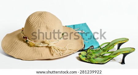 The summer hat, bag and easy sandals lie on a light surface