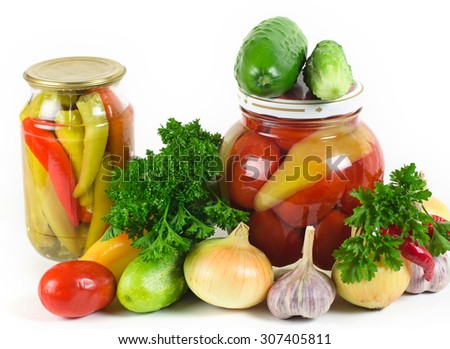onions, garlic, cucumbers, tomatoes and parsley lie on a light surface. A row two banks with tinned vegetables