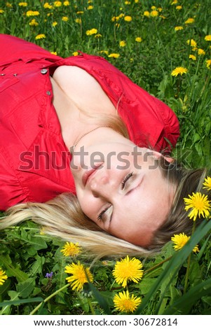 Young girl lying in dandelion meadow