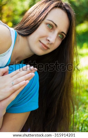 Beautiful young woman doing yoga (Revolved Side Angle Pose) in park