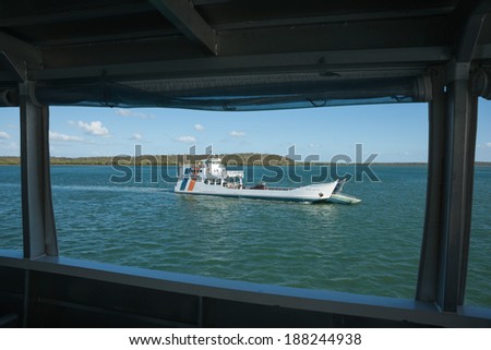 FRASER ISLAND, AUSTRALIA - MARCH 12 - ferries to and from Fraser Island cross mid-trip on March 12, 2014 in Fraser Island, Australia. Ferry returning is framed in the structure of one going.