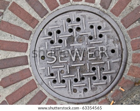 Street manhole for sewer system utility, close-up.