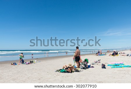 TAURANGA, NEW ZEALAND - DECEMBER 29; People enjoying a summer day outdoors sunbathing and swimming at beach on December 29, 2012 at Omanu Beach Tauranga New Zealand.