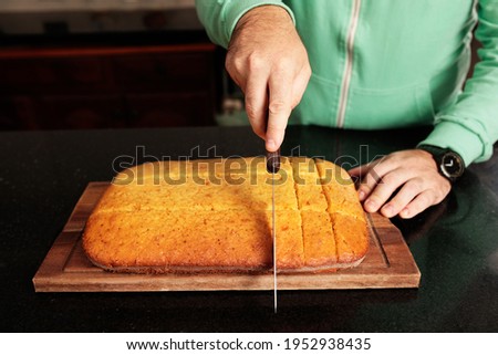 Foto Bild Person, die den Kuchen auf dem Tisch anschneidet