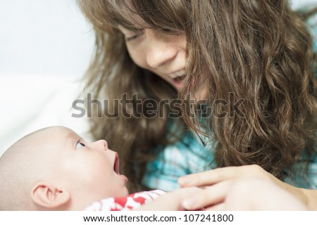 lovely portrait of a caucasian woman speaking to her son lying on cradle