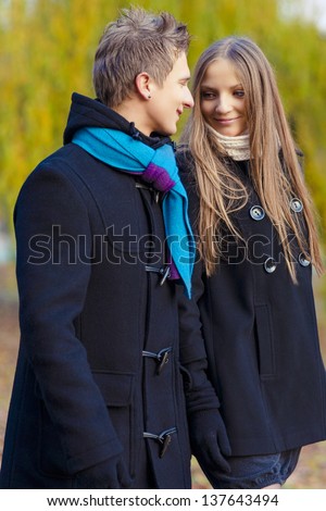 portrait of young caucasian couple walking  together in the  park area