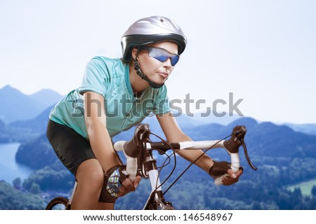 portrait of  woman riding bike outside over natural background and looking forward. model equipped with a professional biking gear and uses professional race bike. composite image. horizontal