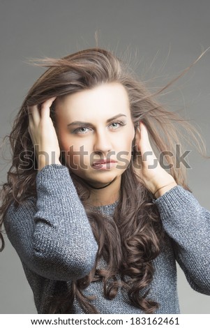 Hair Concept: Sensual Brunette Woman With Fly Away Hair. Isolated Over Gray Background.Vertical Image