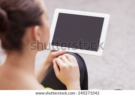 Back View Portrait of Woman Holding Tablet Computer. Focus on Tablet Computer. Horizontal Image