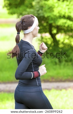 Sport Training Concept: Back View of Caucasian Brunette Woman Running Fast. Vertical Image Orientation
