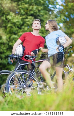 Two Young Caucasian Professional Cyclists Together with Their Bicycles Outdoors. Vertical Shot