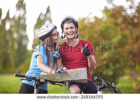 Sport and Fitness Concept. Happy caucasian Couple of Cyclists With Location Map Outdoors.Horizontal Image Composition