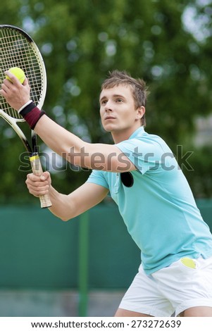 Sport and Tennis Concept: Handsome Caucasian Man With Tennis Racket Preparing to Serve Ball On Court. Vertical image