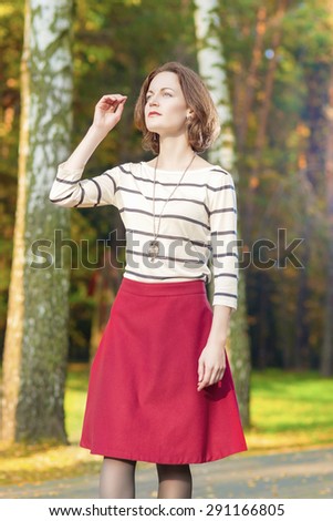 Dreaming Caucasian Brunette Woman in Fashion Clothing Posing in Fall Forest Outdoors. Vertical Image Orientation