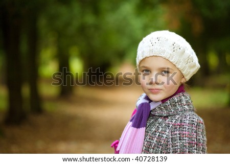 portrait of young pretty girl in white fashion beret standing with tilted head and little smile