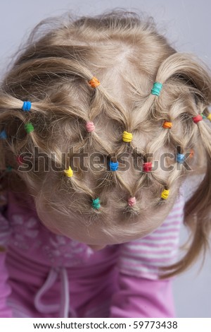 head of young blond caucasian girl with unique hair tails design and pattern. from above view. isolated