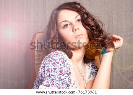 soft and gentle shoot of young caucasian brunette sitting with lifted head and looking appear. shoot with lens flare