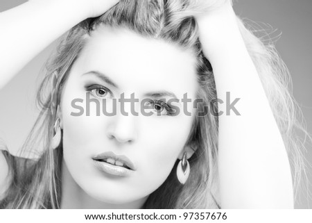 beautiful black and white portrait of nice caucasian blonde woman with hands lifted and staring