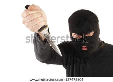 Masked man aims with knife - stock photo