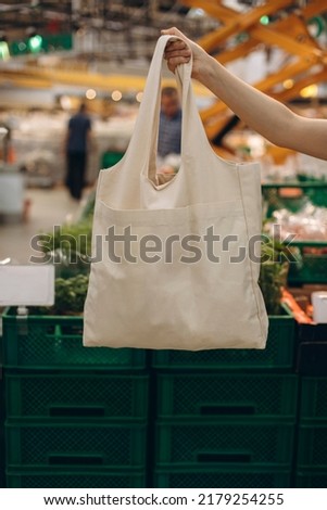 Similar – Foto Bild Hand mit einer wiederverwendbaren Einkaufstasche und frischen Orangen auf einem schwarzen Hintergrund