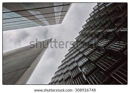A coloured photo looking up capturing three different buildings on an 45 degree angle with added extreme contrast filter. Images has a black film looking border applied to it