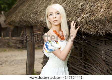 21 Mpix full-frame HD-capture. Professionally retouched. Rural woman standing by old traditional Ukrainian house