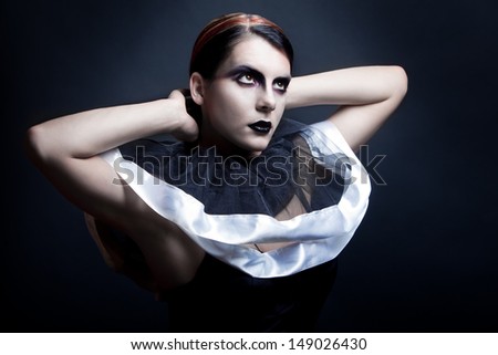 Professionally retouched stylized photo of a fashion young woman on dark background. Saturation effect added for dramatic effect