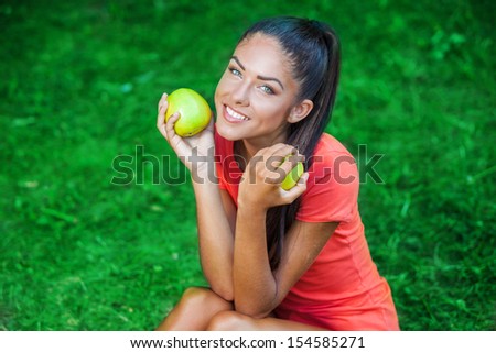 young beautiful brunette woman holding two apples