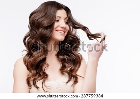 Beautiful Woman with curly brown hair close up. Youth Skin anf Hair Care Concept