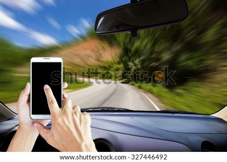 Image of windshield on the road ,way and highway, Drivers use smart phones while driving .