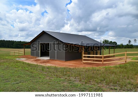 Horse barn built with post frame materials; two lean-to's, two sliding barn doors, six stalls, concrete floor Foto d'archivio © 