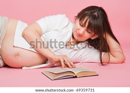 The pregnant woman reads the book