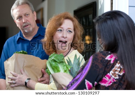 A look of surprise emotion is on the recipients faces as a charity relief worker brings bags of food and groceries to the hungry.