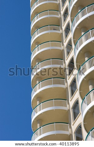 Terraces of modern condominium, used as vacation rentals, rise against a blue sky.