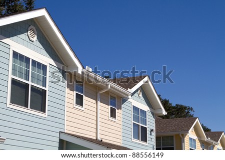 New modern rental apartments with horizontal siding against a blue sky background.