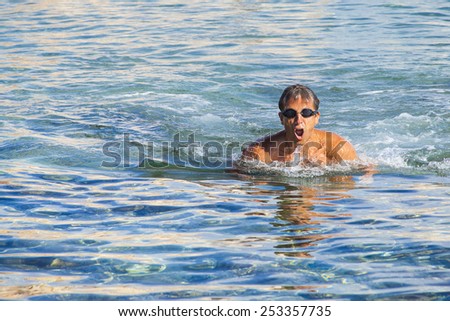 The man swims in the sea at the coast of Spain