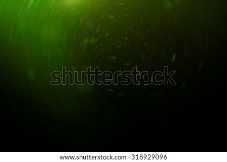 Abstract green background with floating and reflecting dust, radial motion blur