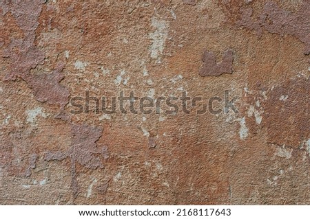 The outer surface of the wall of an old building with peeling off plaster. Abstract background. The texture of the dilapidated multilayer building material. Close up. Terracotta color. Copy space. Photo stock © 