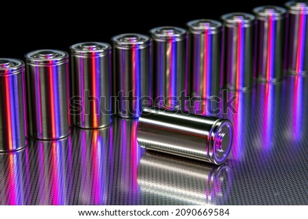 A consignment of new modern high-capacity lithium-ion cells. A prototype of new batteries on a steel surface illuminated with red and blue light on a black background Stok fotoğraf © 