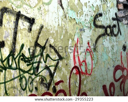 Graffiti tags on a wall with peeling paint