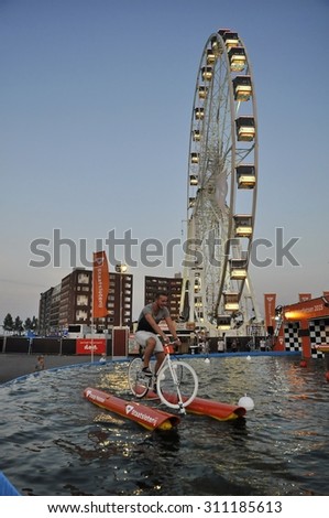 Java Island, Amsterdam, the Netherlands - August 22, 2015: A volunteer riding the water bike, at the time of the SAIL 2015 (www.sail.nl), an international public nautical event held every 5 years.