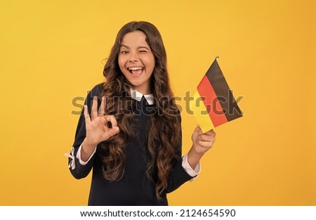 happy winking child hold german flag yellow background showing ok gesture, education abroad Foto stock © 