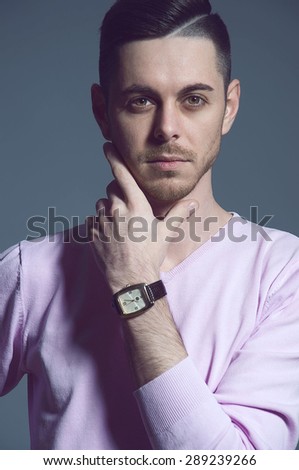 Portrait of a beautiful young man with wrist watches in studio.Close-up photo