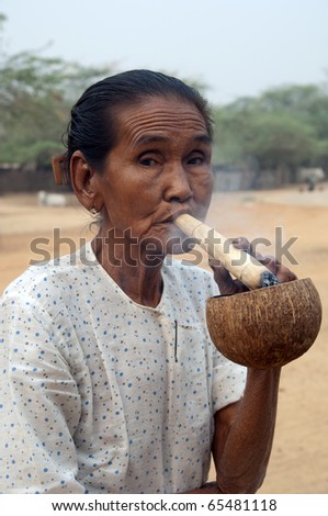 YANGON, MYANMAR - JUL 24: Old burmese woman smokes a cheroot cigar, July 24, 2010 in Yangoon, Myanmar. Cheroots are traditional cigars smoked by older people in Burma.